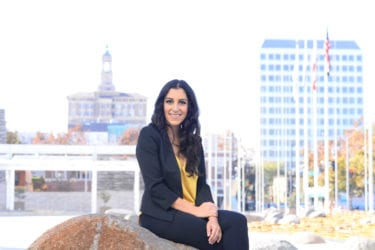 Ramona Giwargis A woman sitting on a boulder outside City Hall in San Jose, California