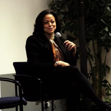 A woman sitting in a chair holding a microphone