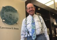 A man in a tie and suspenders stands inside a government office