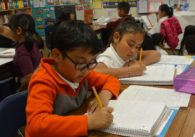 Children writing in a classroom