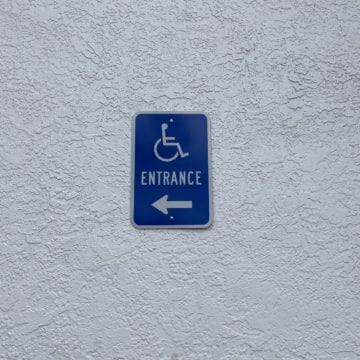A wheelchair-accessible sign on an exterior wall