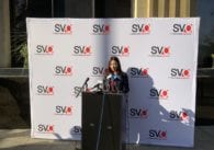 A woman stands at a podium at a news conference in San Jose