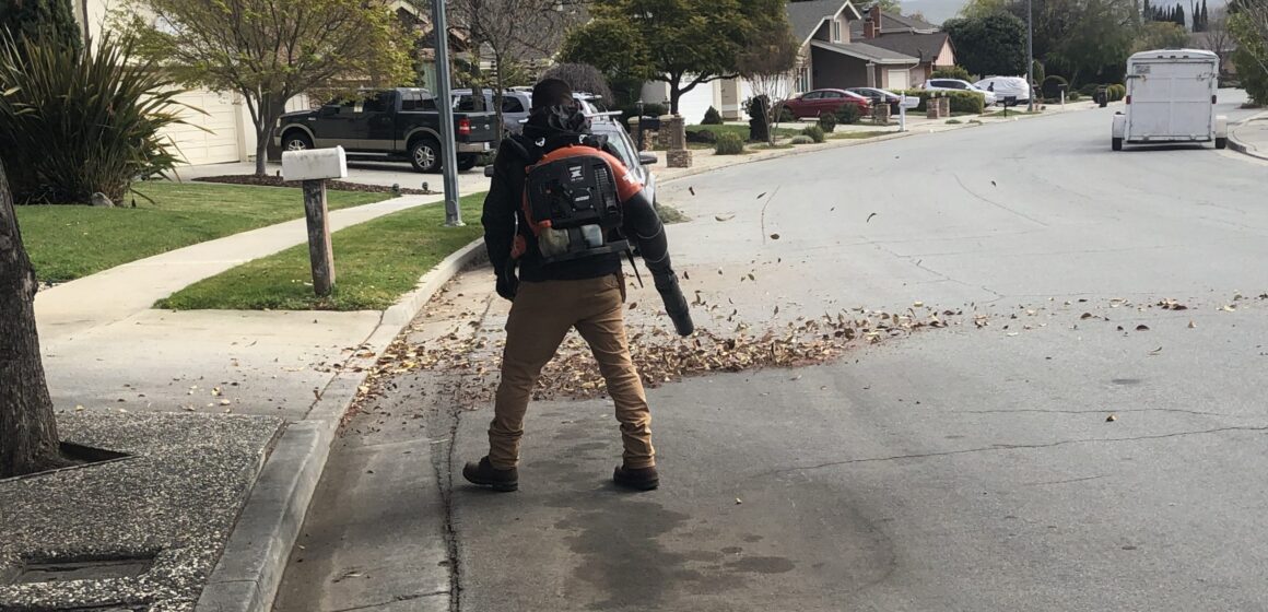 A person using a leaf blower on a street in San Jose, California