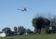 A plane flies over homeless camps on parkland in San Jose