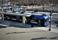 A public transit bus at a stop on a downtown street