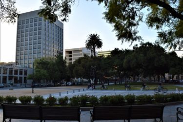 People riding their bikes through a plaza in downtown San Jose, California