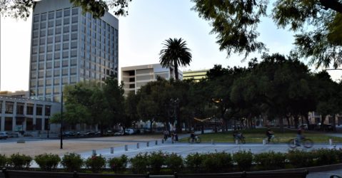 People riding their bikes through a plaza in downtown San Jose, California