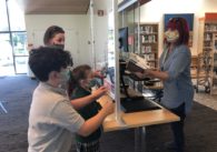 Terra Vitarelli and her children, Luca and Michaela, pick up books placed on hold at the Mission Branch Library in Santa Clara. Photo by Lorraine Gabbert.