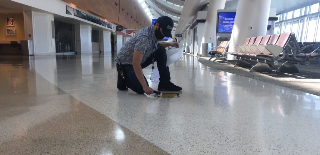 A worker at Norman Y. Mineta-San Jose International Airport cleans a social distancing floor sticker at one of the terminals. Photo courtesy of Norman Y. Mineta-San Jose International Airport.