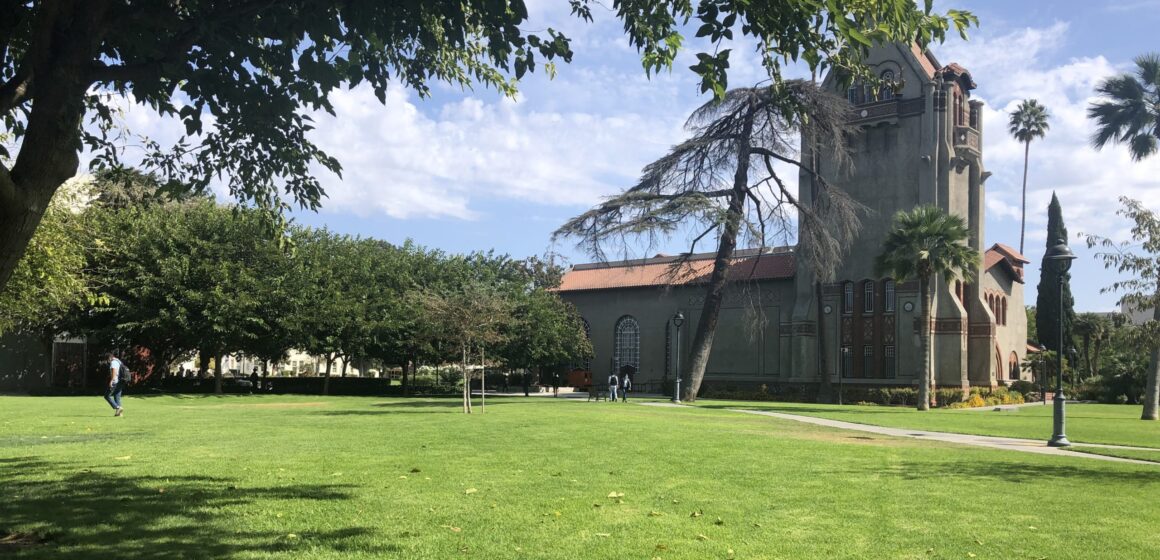 A grass field in front of a building on campus at San Jose State University