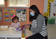 Mother and daughter reading a book in a day care.