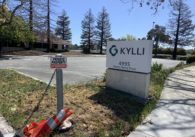 A sign in front of an outdoor parking lot