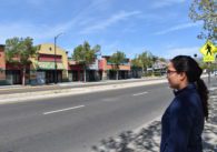 A woman standing outside looking at buildings across the street