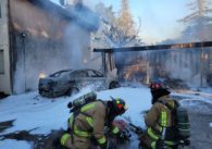Two firefighters putting out a structure fire