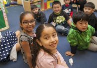 A group of children sitting on the floor of a classroom