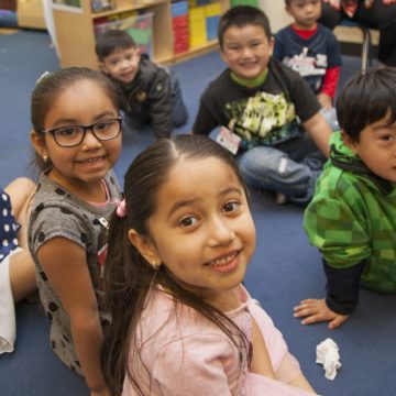 A group of children sitting on the floor of a classroom