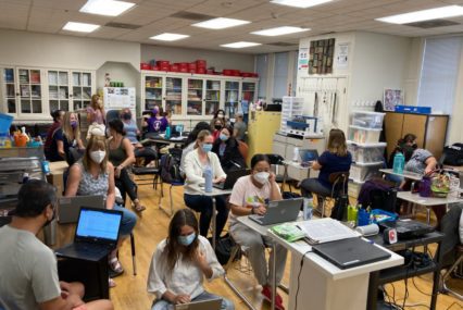 A group of special education teachers wearing face masks working in a classroom