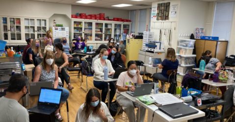 A group of special education teachers wearing face masks working in a classroom