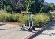 Two electric scooters on the sidewalk