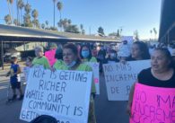 A group of tenants march in a protest holding signs