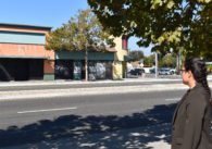 A woman standing outside looking at buildings across the street