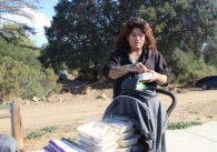 A woman with a stroller of supplies