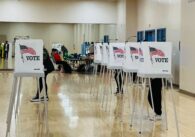People at voting booths inside an elections office