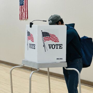 A person standing at a voting booth
