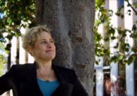 A woman standing in front of a tree
