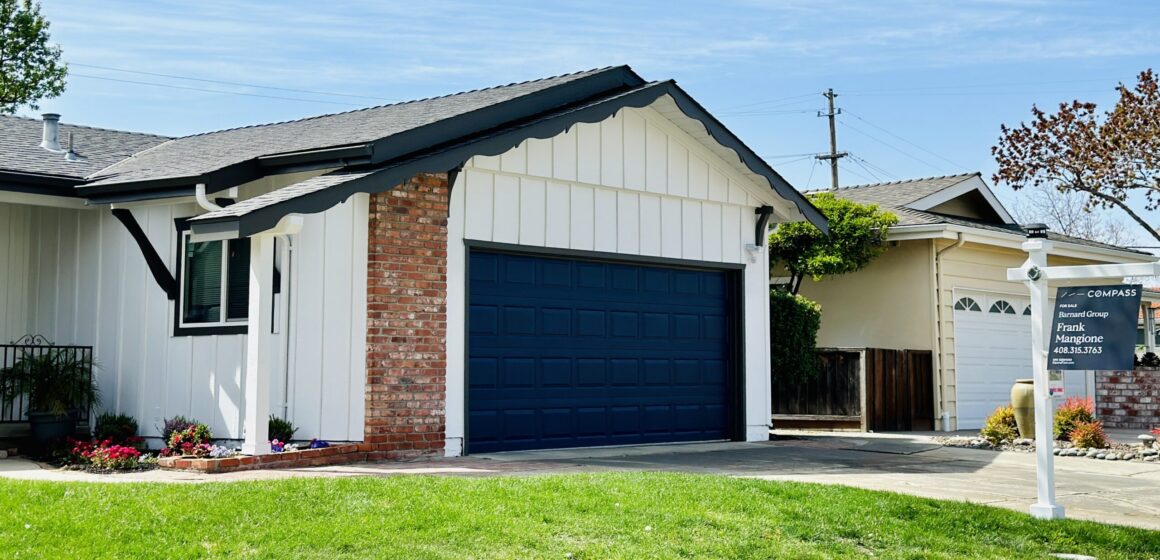 A single-family home with a for sale sign next to the lawn