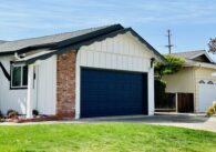 A single-family home with a for sale sign next to the lawn