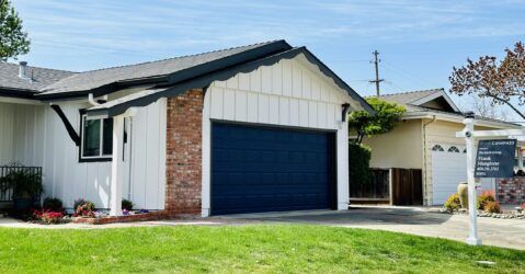 A single-family home with a for sale sign next to the lawn
