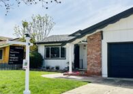 A house in San Jose with a for sale sign on the lawn.