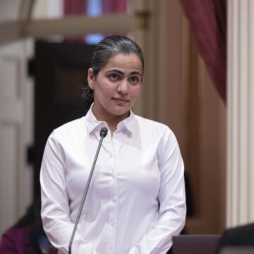 A woman stands on the floor of the California Senate