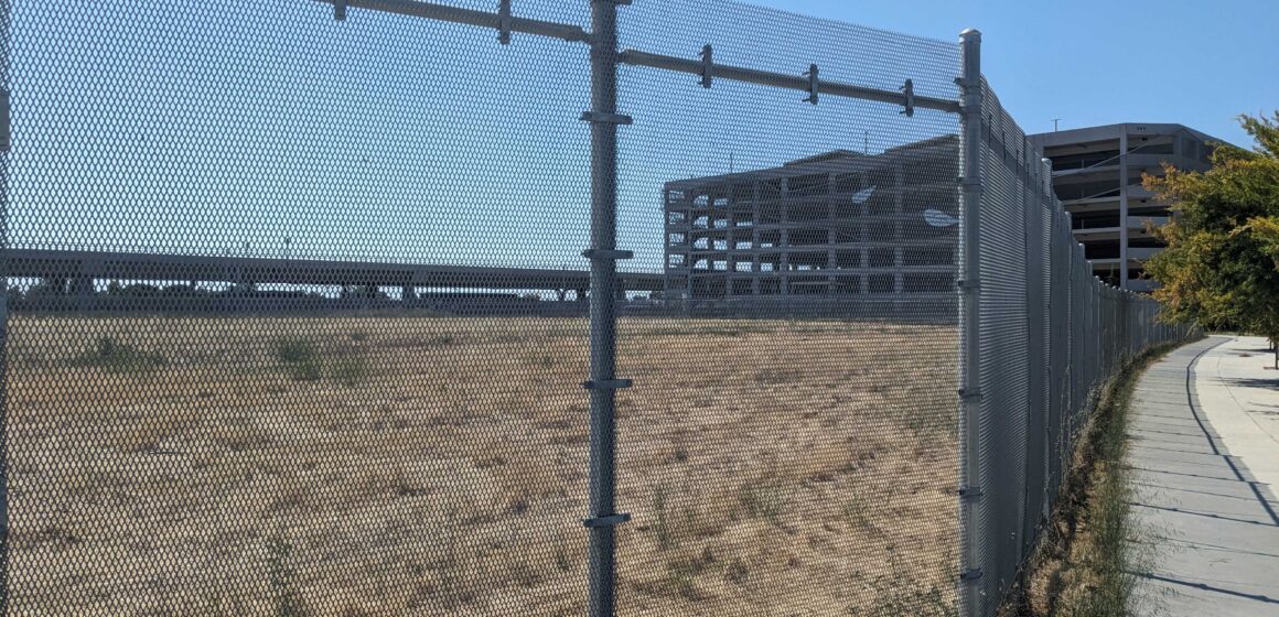 Empty land behind a fence near a transit stop in San Jose, California