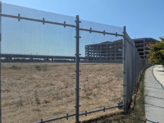 Empty land behind a fence near a transit stop in San Jose, California