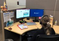 A nurse sits at a desk facing computers at a dispatch center in San Jose, California