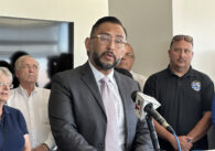 A man stands speaking at a podium