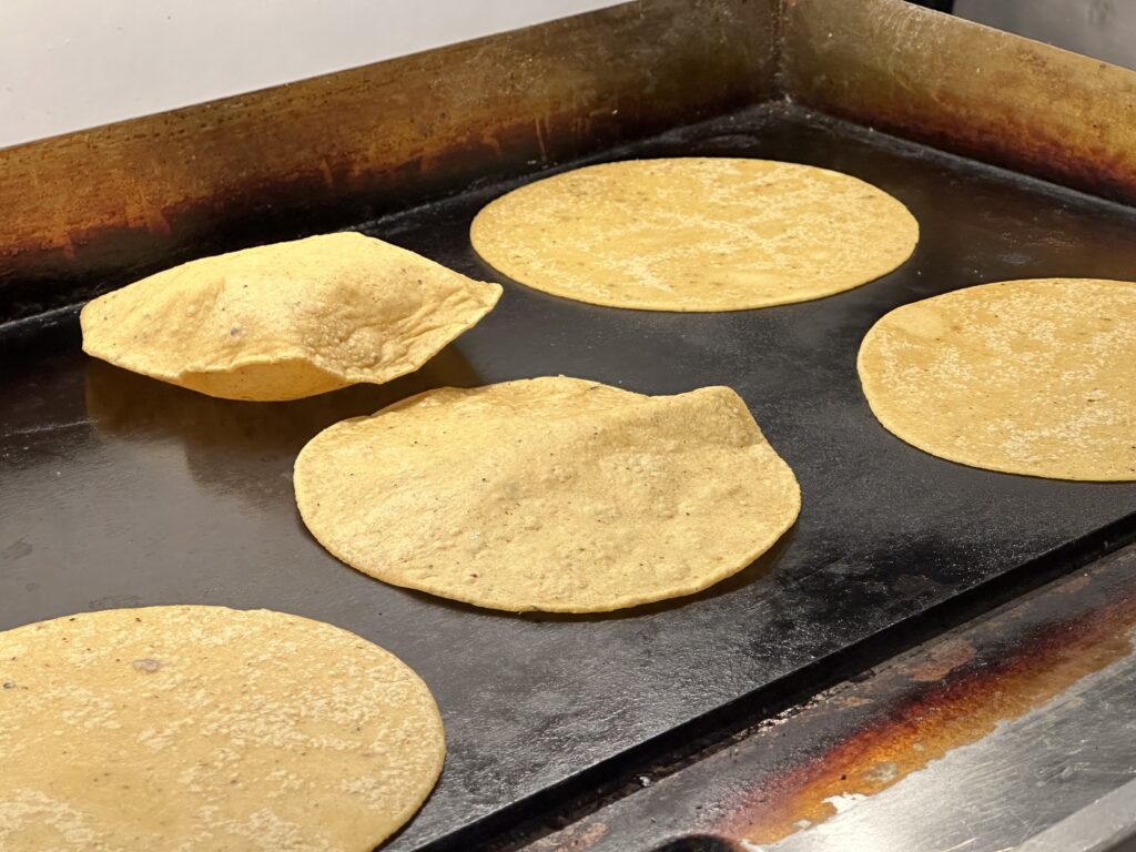 Fresh corn tortillas puffing up. Photo by Robert Eliason.