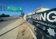 A police recruitment banner along the side of a street