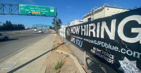A police recruitment banner along the side of a street