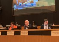 Milpitas interim city manager Ned Thomas speaking and sitting behind the city council dias. City attorney Michael Mutalipassi and Vice Mayor Evelyn Chua sit beside him.