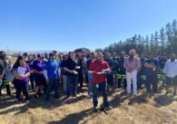 AFSCME Local 1101 President Steve Jovel speaks in front of a crowd of about 50 at the VTA Cerone Yard, standing at a podium over a field of dried grass.