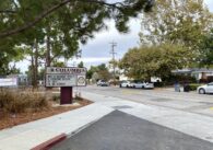 Sign for Columbia Middle School in Sunnyvale, listing dates for school events, showing the school's drop-off driveway and the street in front of the school