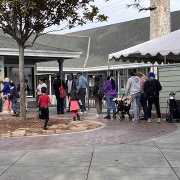 THANKSGIVING A line of people stand outside waiting to pick up food