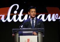 A man in a suit standing at a podium