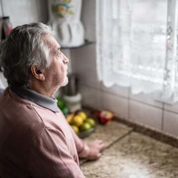 A contemplative senior man at home.