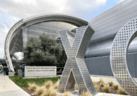 Statue of X and O in front of San Jose airport Terminal B with airport sign in back