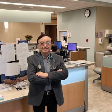 Man standing in front of office cubicles in doctor's office