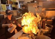 A chef cooks shrimp inside a restaurant kitchen
